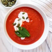 beetroot and sweet potato soup in a white bowl.