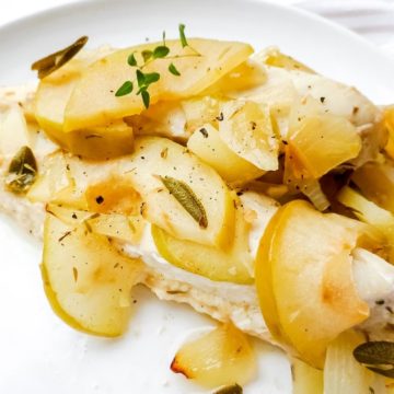 baked chicken with apples and honey on a white plate