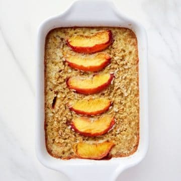 baked peach oatmeal in a white dish