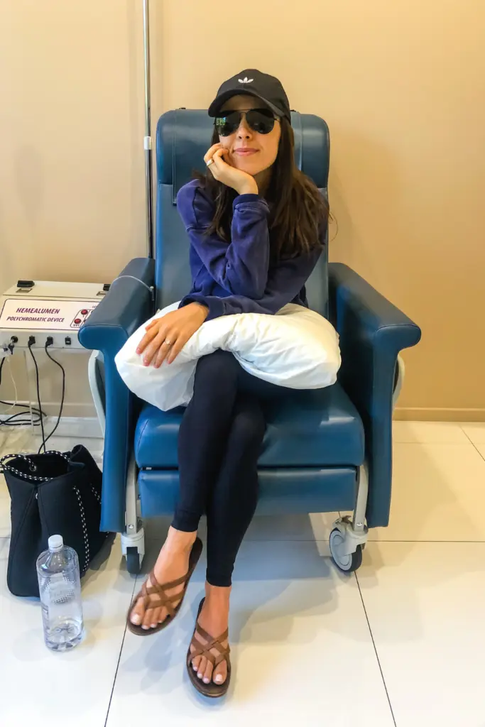 woman in a hospital chair with a pillow on her knees.