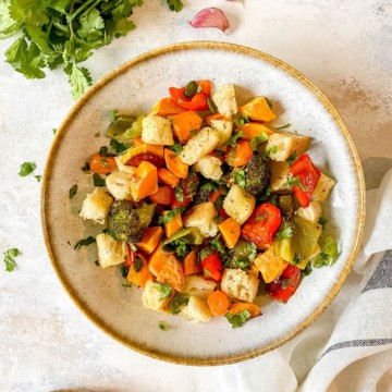 roasted vegetable panzanella salad in a grey bowl