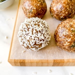 coconut energy balls on a wooden board.