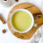 spiced milk in a cup on a wooden board.