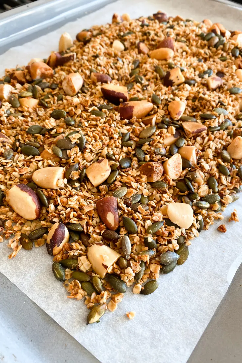 ginger brazil nut granola on a baking tray lined with parchment paper.