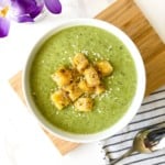 overhead view of a white bowl of broccoli and cauliflower soup.