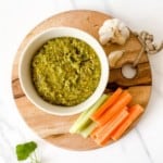 overhead view of pistachio pesto on a wooden board.