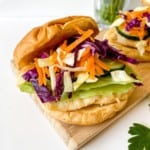 honey chicken burger in a bun on a wooden board.