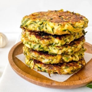 zucchini and mascarpone fritters on a wooden plate.