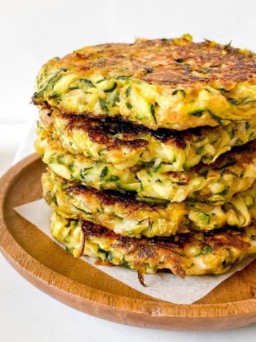 zucchini and mascarpone fritters on a wooden plate.