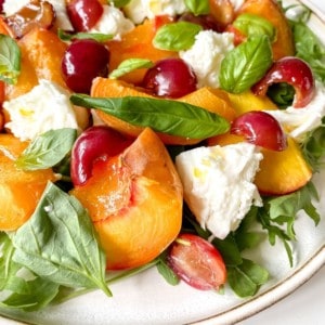 stone fruit caprese salad on a brown rimmed plate.