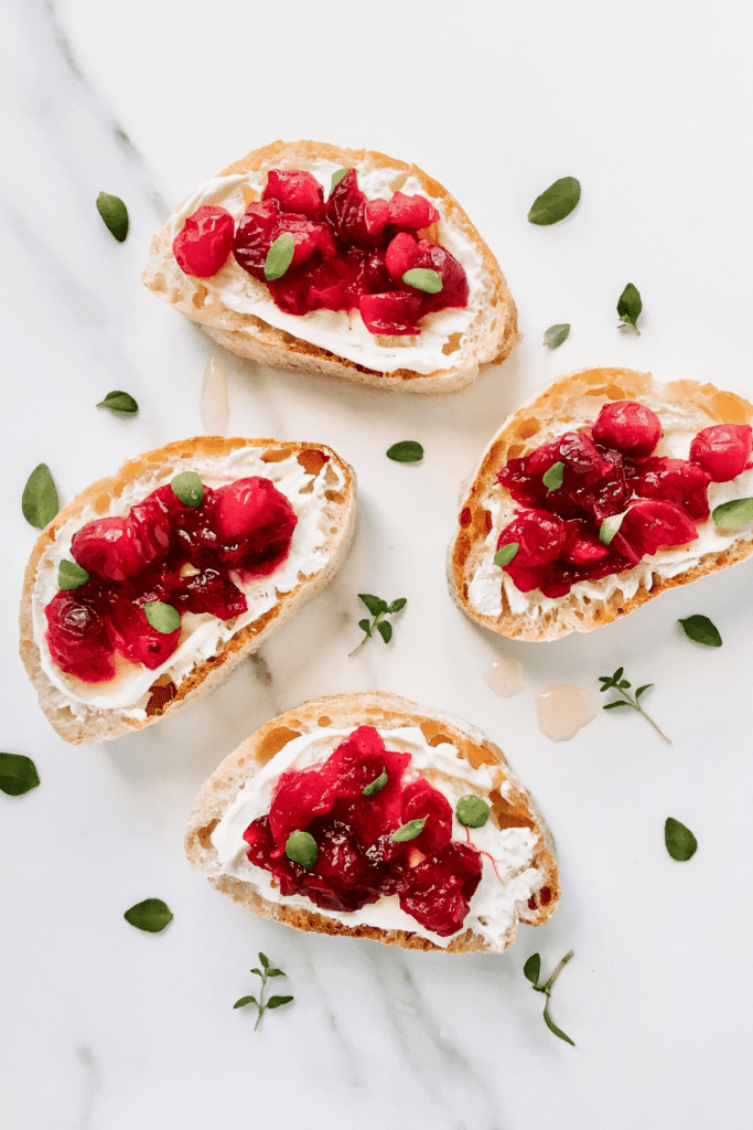 cranberry cream cheese toasts sprinkled with herbs