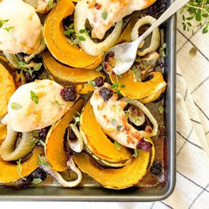 sheet pan chicken and squash with fennel on a checked cloth.