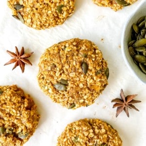 pumpkin spice oat cookies with star anise and pumpkin seeds next to them.