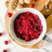 cranberry sauce in a white bowl on a wooden board.
