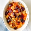 honey roasted vegetables with rosemary in a white dish.
