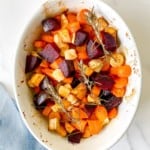 honey roasted vegetables with rosemary in a white dish.