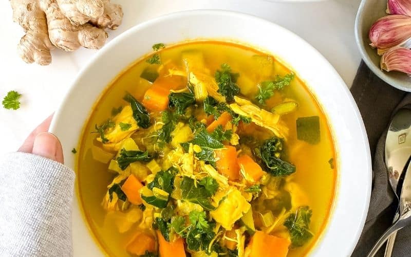 turmeric chicken soup in a white bowl
