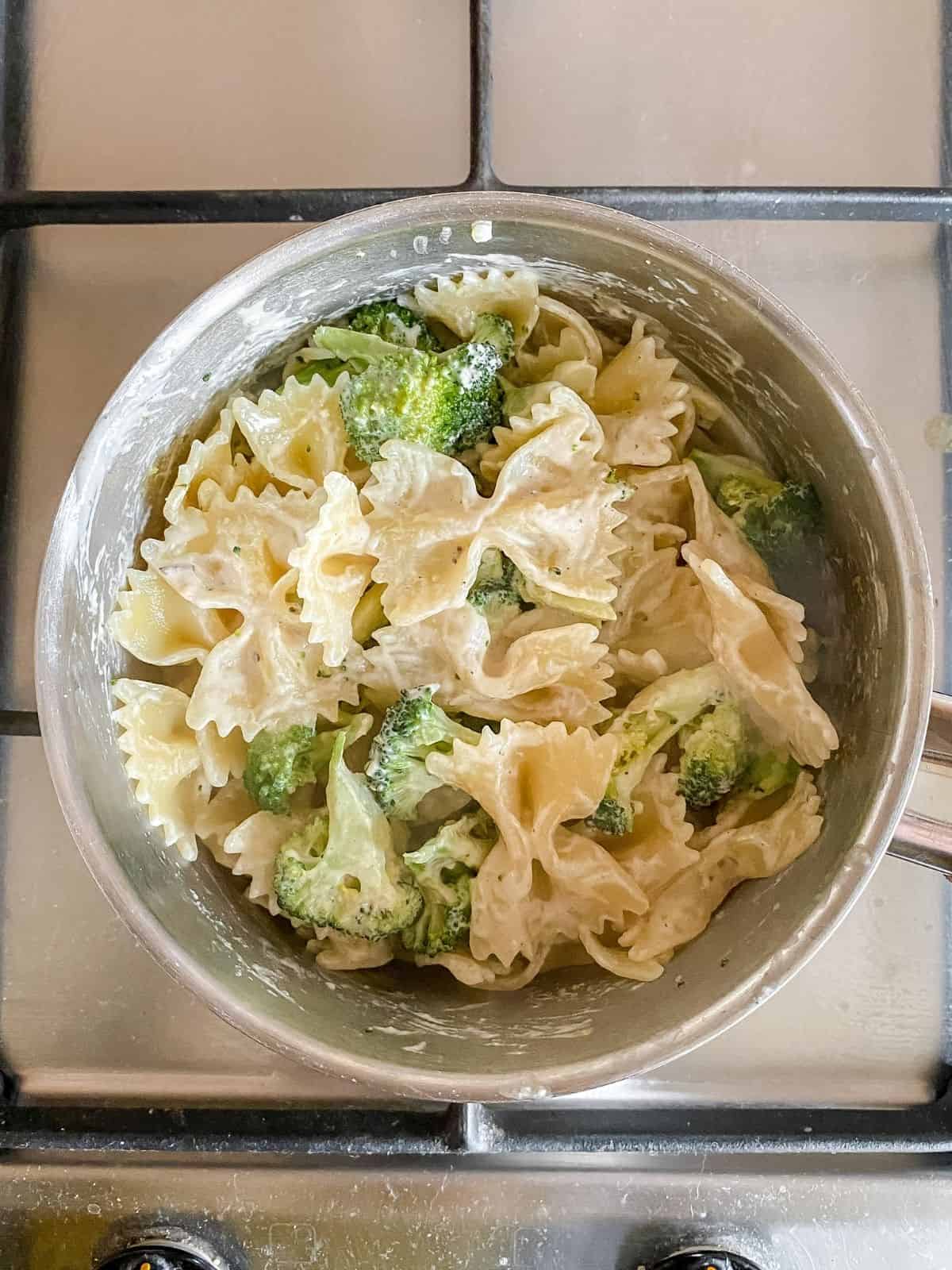 tahini broccoli pasta in a pot on a stove top.