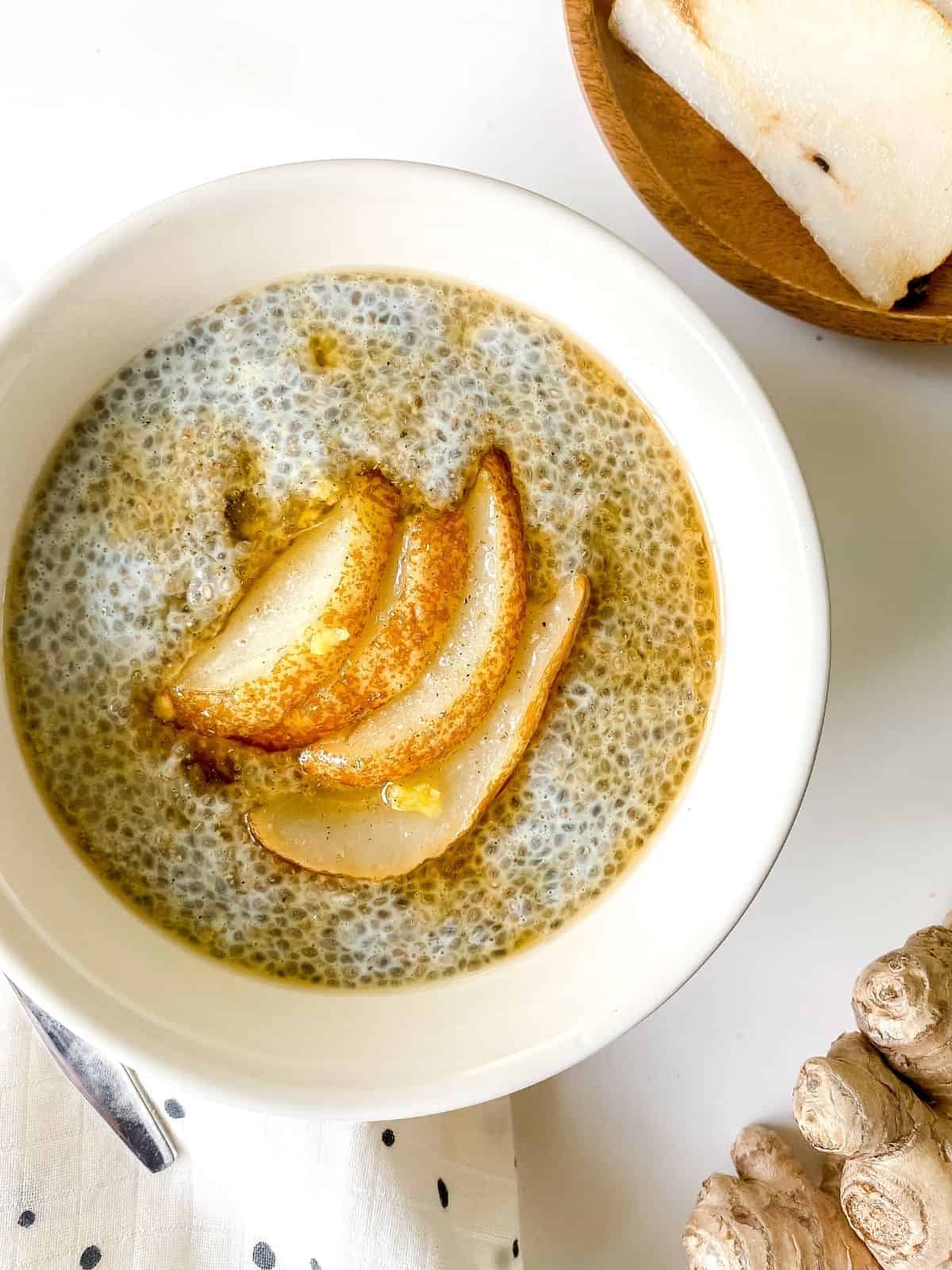 spiced pear chia pudding in a white bowl.