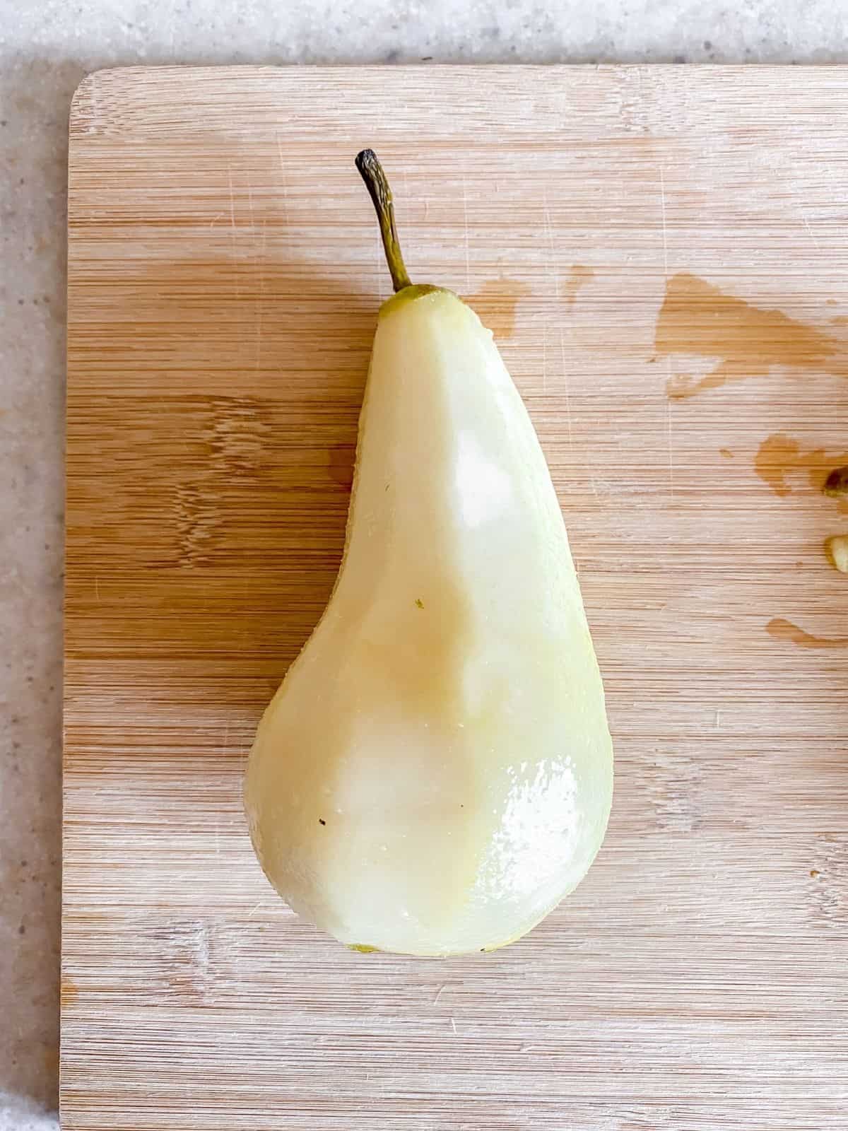 peeled pear on a chopping board.