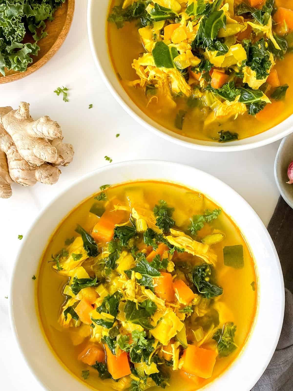 turmeric chicken soup in white bowls.