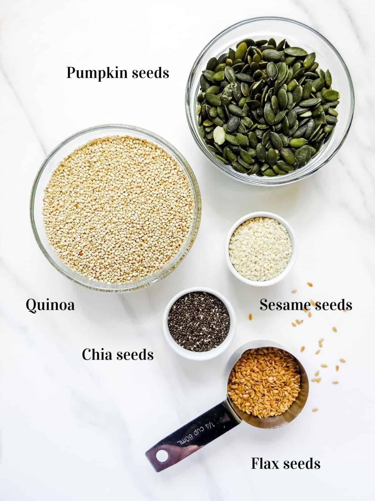 bowls of pumpkin seeds, quinoa, sesame seeds, flax seeds and chia seeds.