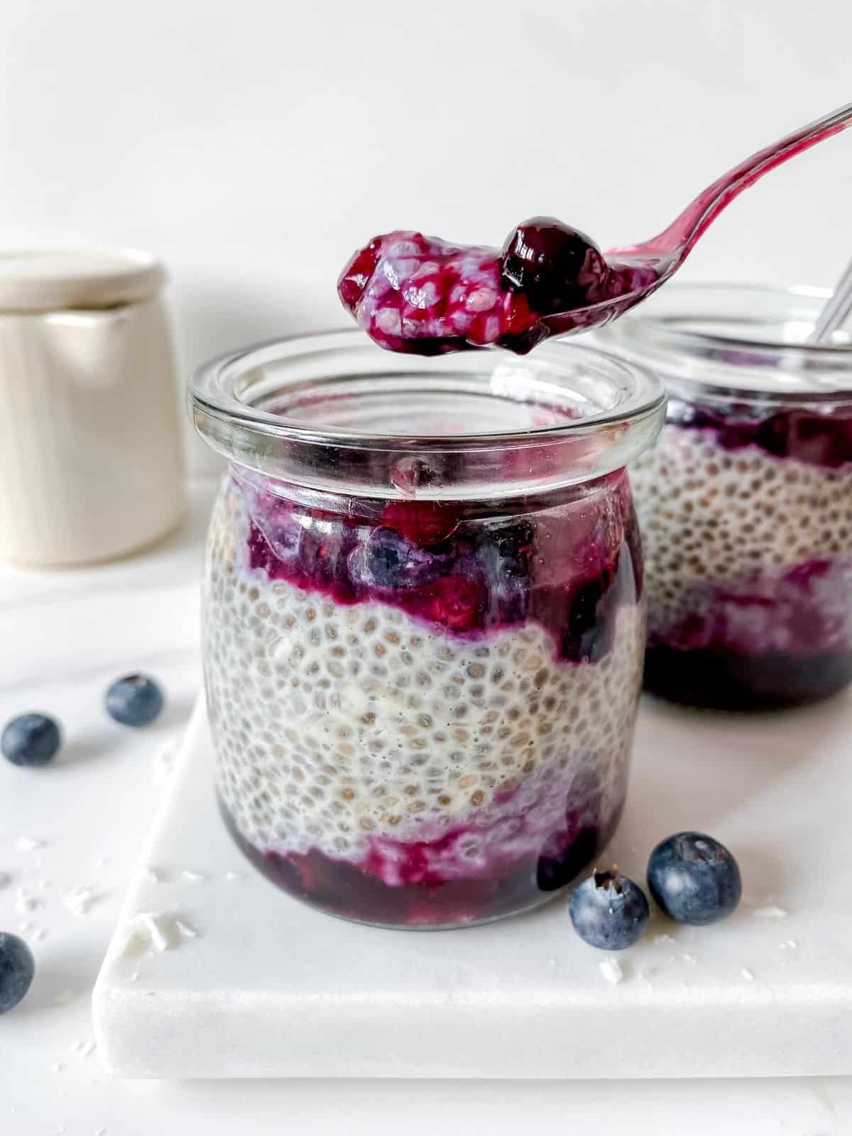 cardamom chia pudding with a spoonful raised above it.