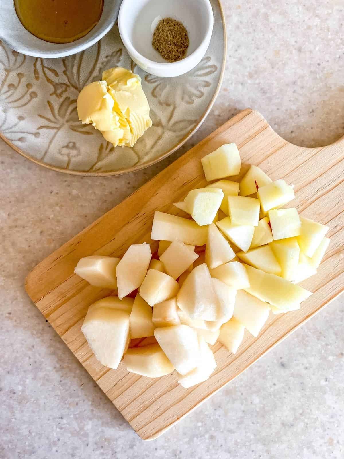 chopped apple and pear on a wooden chopping board.