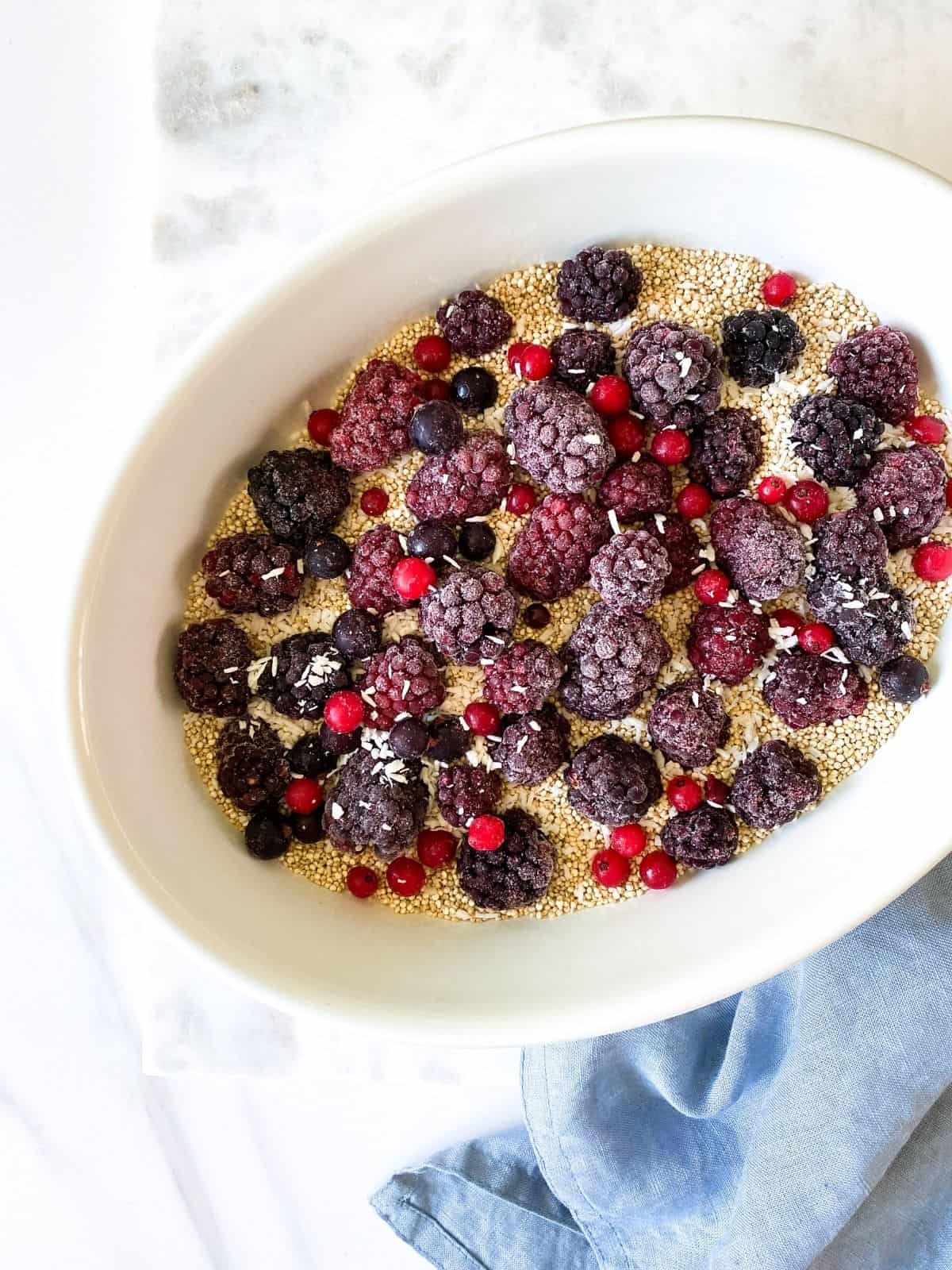 blackberries, red currants and quinoa in a white baking dish.