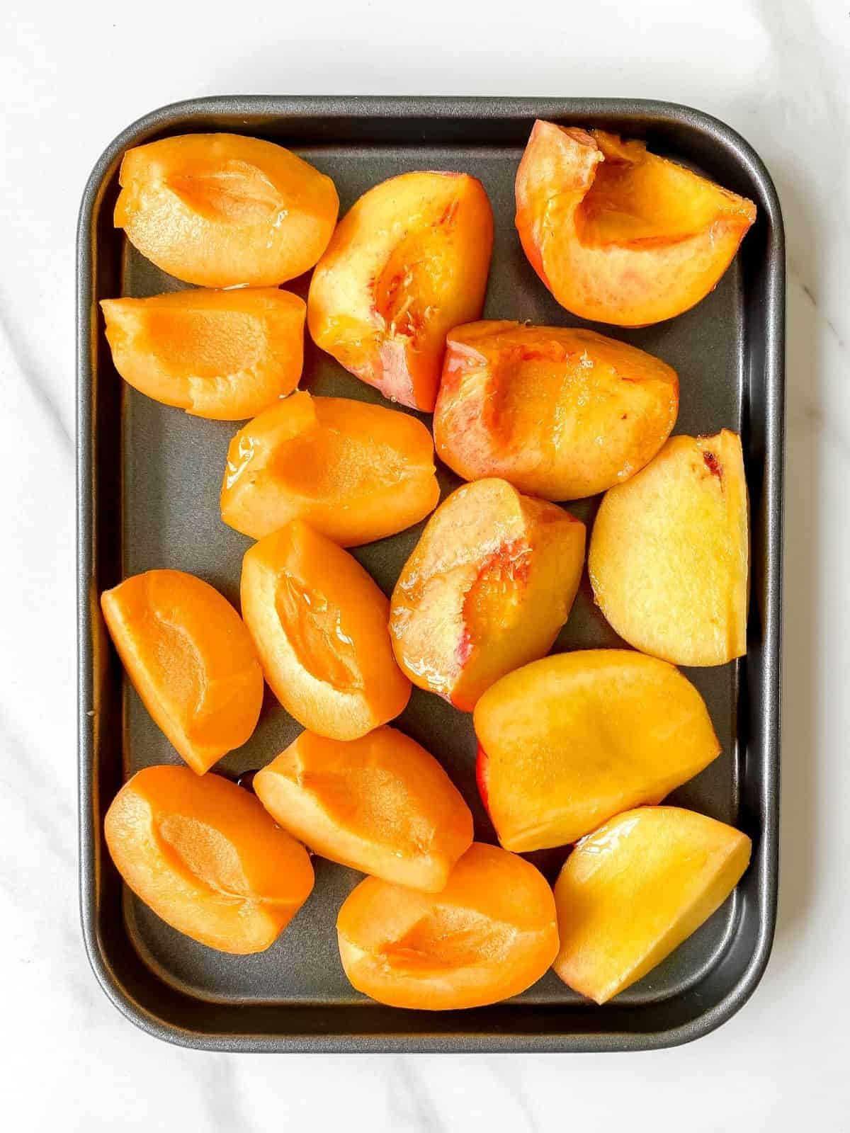 peaches and nectarines on a baking tray.