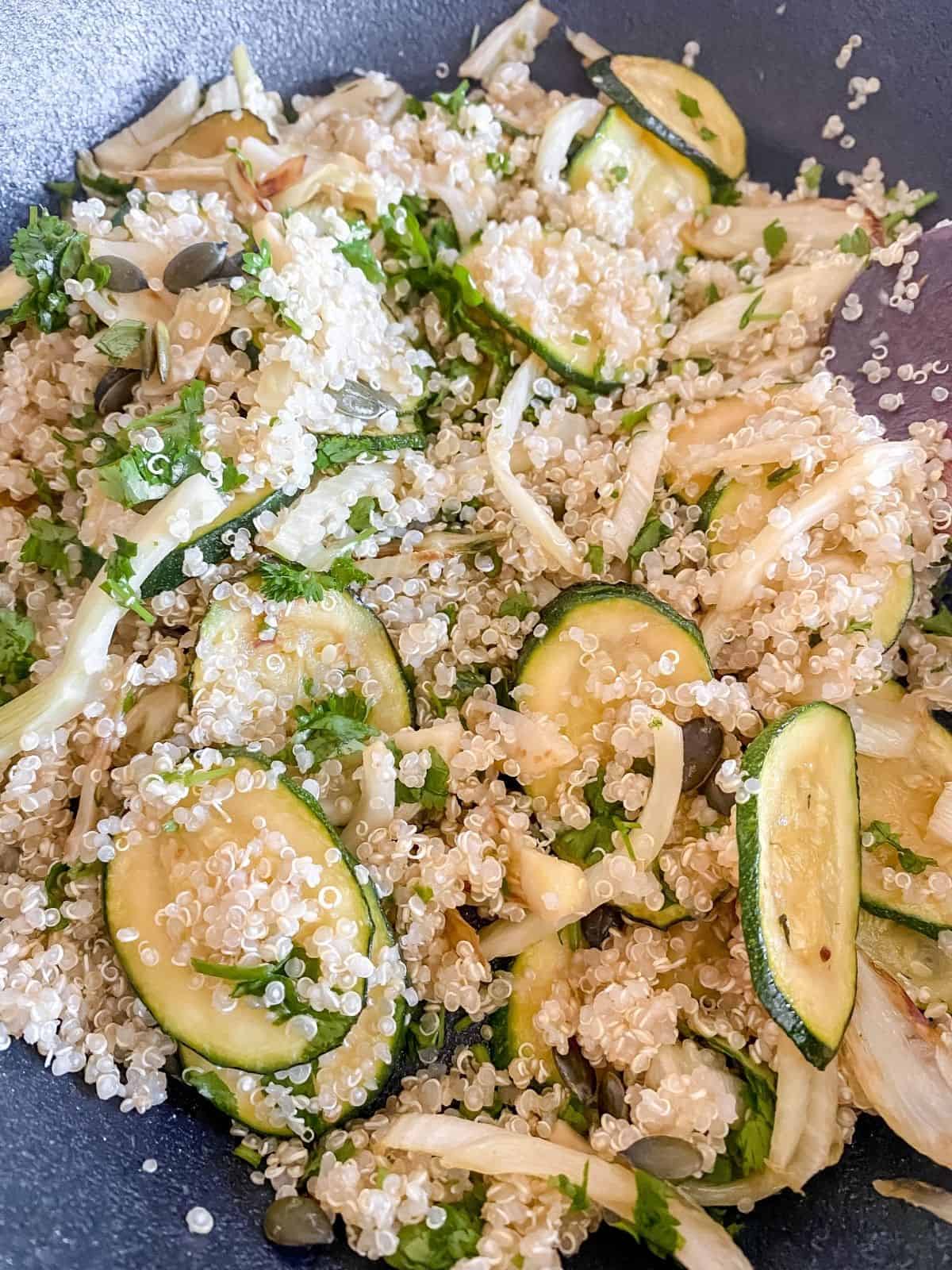 quinoa, fennel and zucchini cooking in a black skillet.