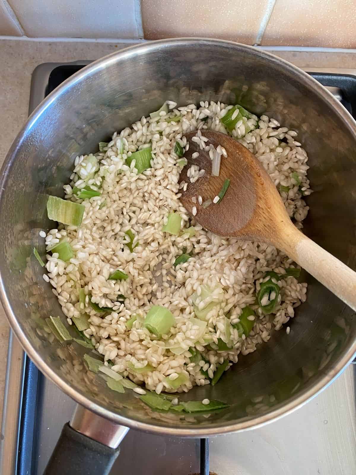 rice and leeks in a pan.