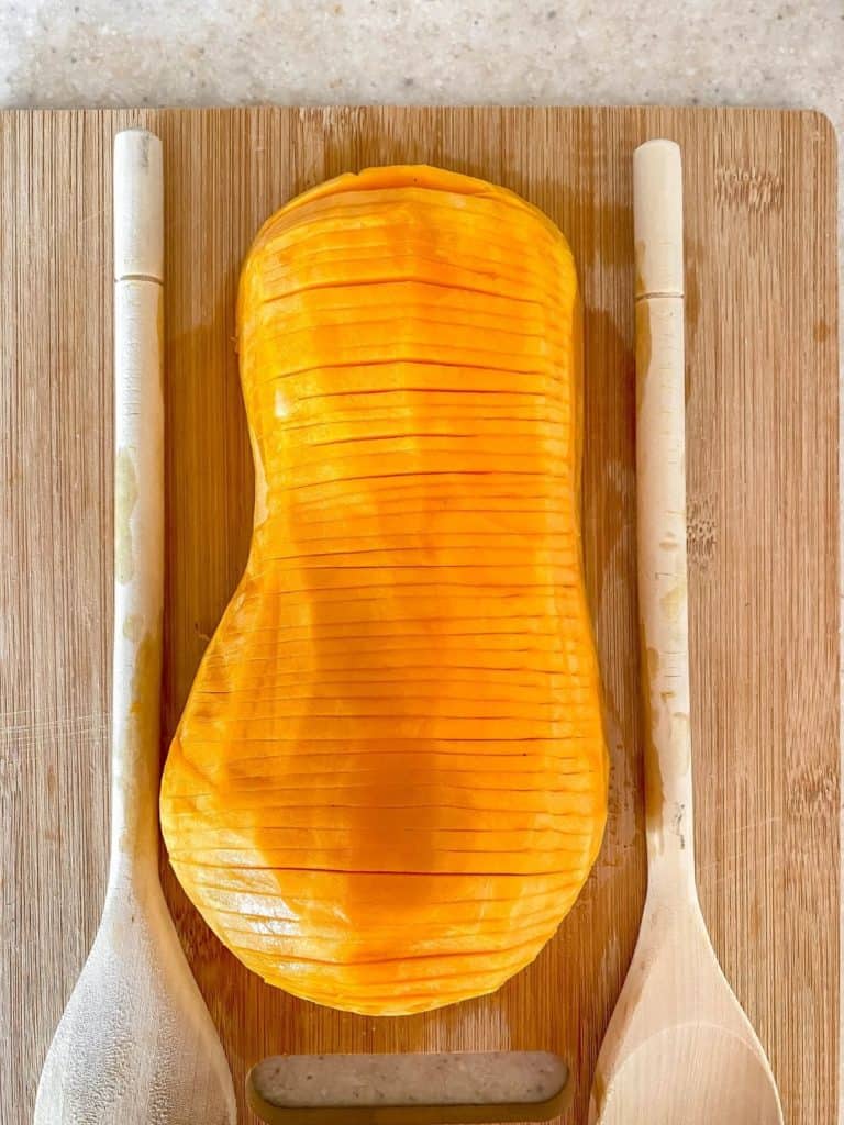 sliced butternut squash with spoons either side of it.