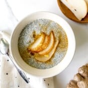 spiced pear chia pudding in a white bowl on a spotty cloth.
