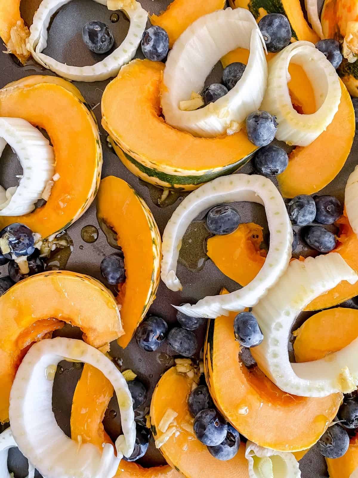 squash, fennel and blueberries on a baking tray.
