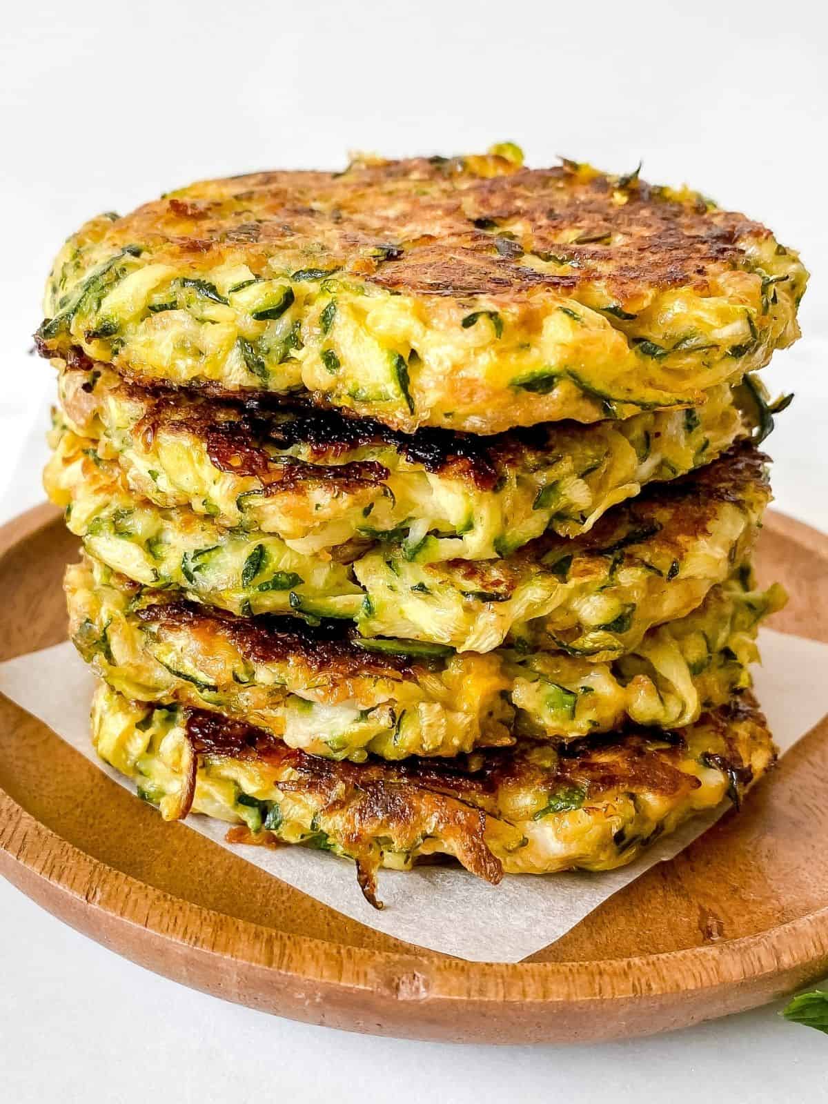close up of zucchini and mascarpone fritters on a wooden plate.