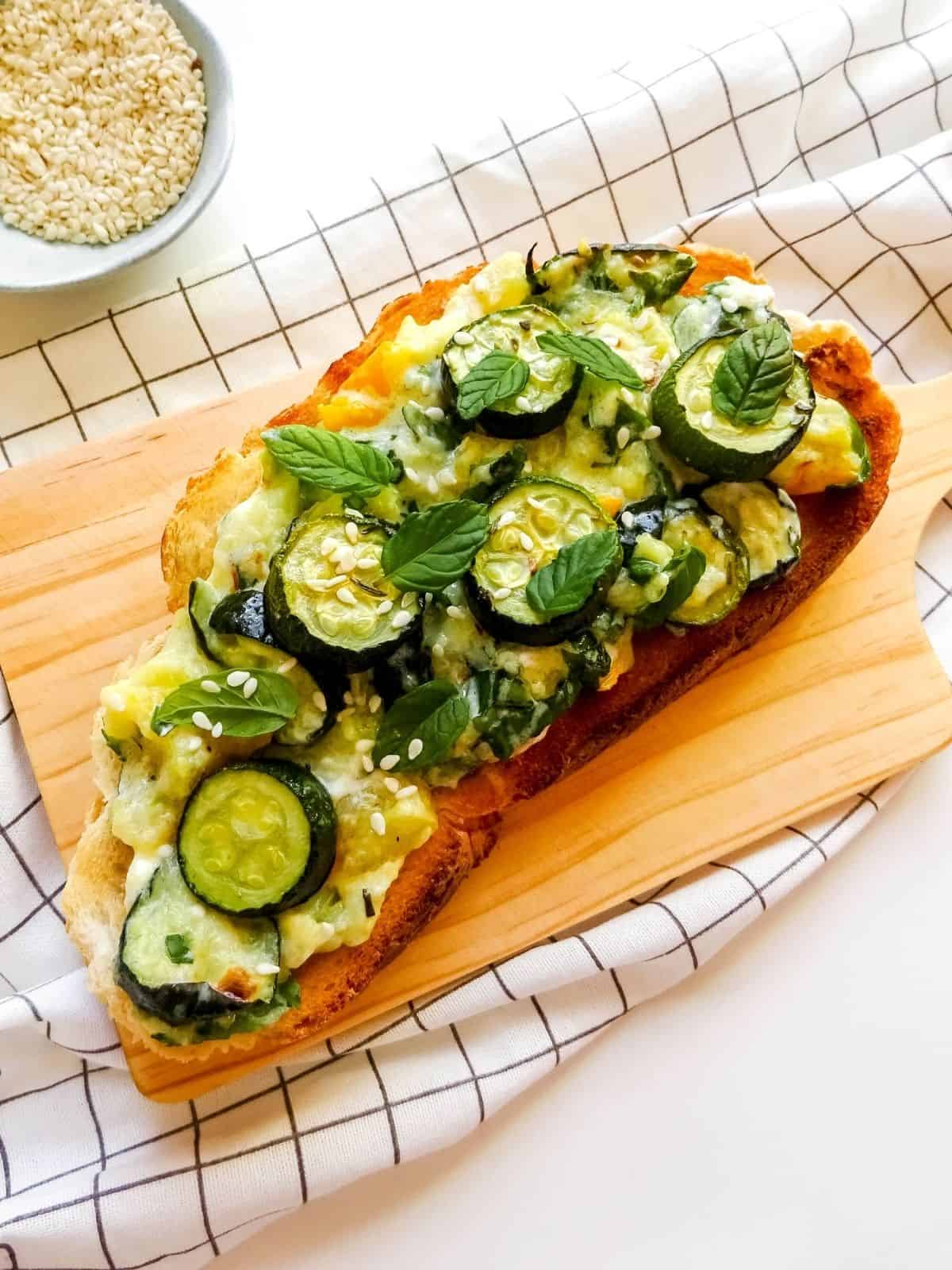 zucchini cheese toast on a wooden board.