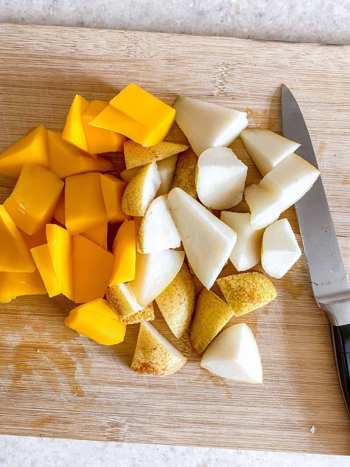 diced pear and mango on a chopping board.