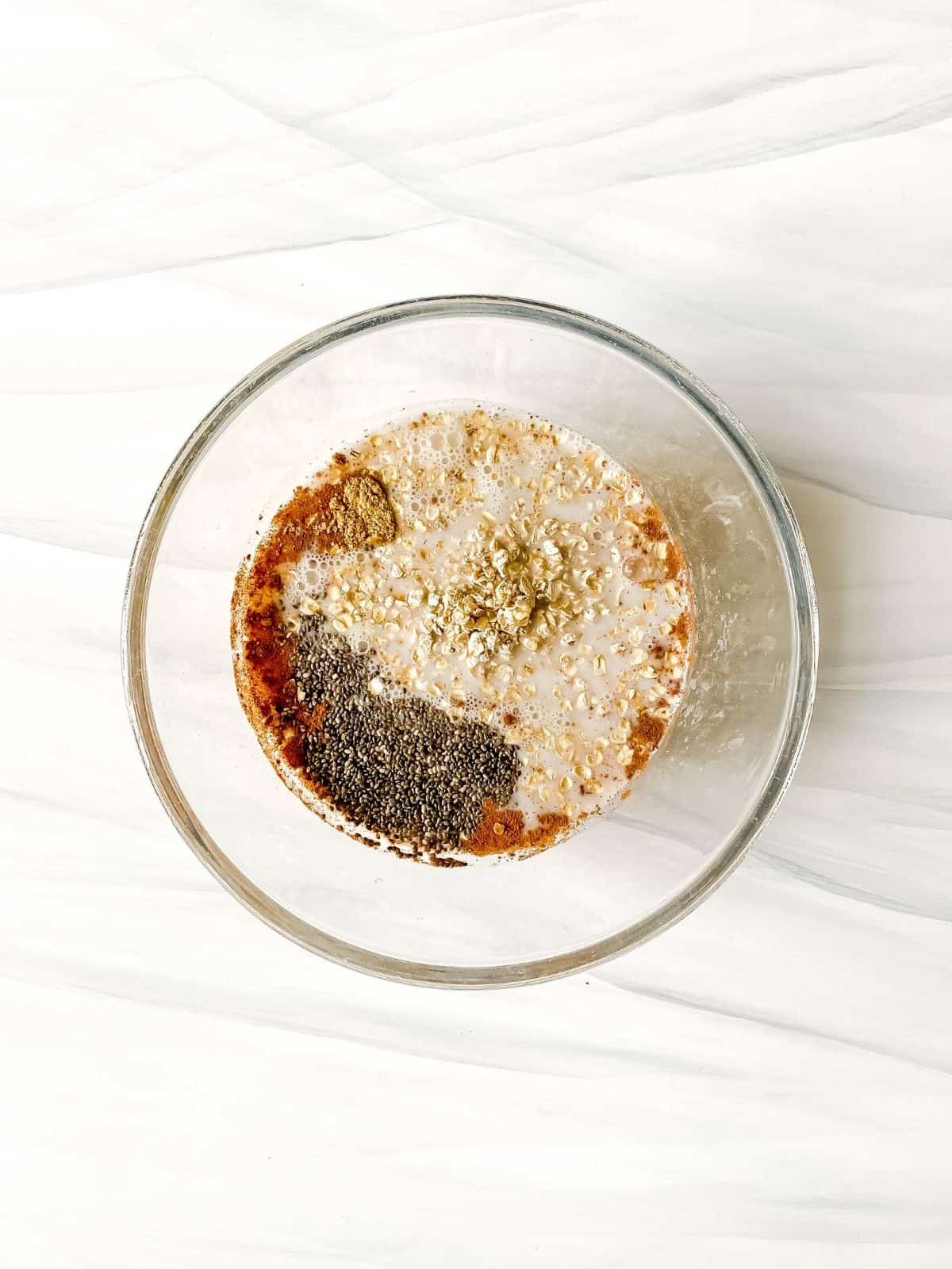 oats, chia, cinnamon and milk in a bowl.