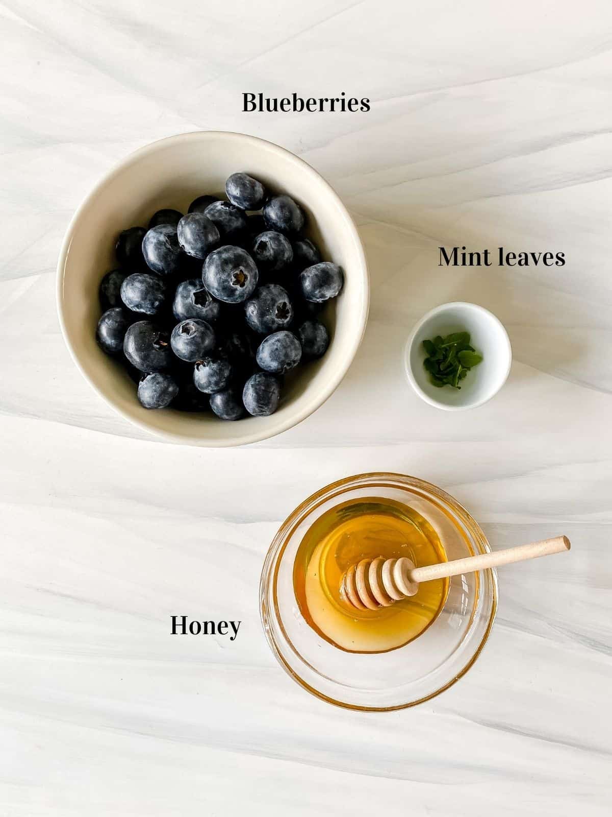 blueberries, mint and honey in small bowls.