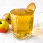 apple ginger chia fresca in a glass with apples in the background.