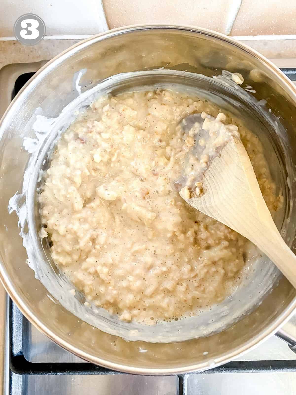 apple porridge in a saucepan with a spoon in it.