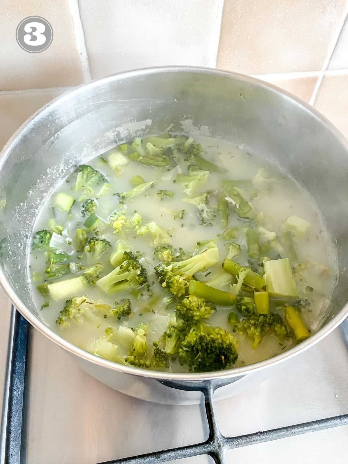 broccoli and asparagus in a saucepan in broth labelled number three.