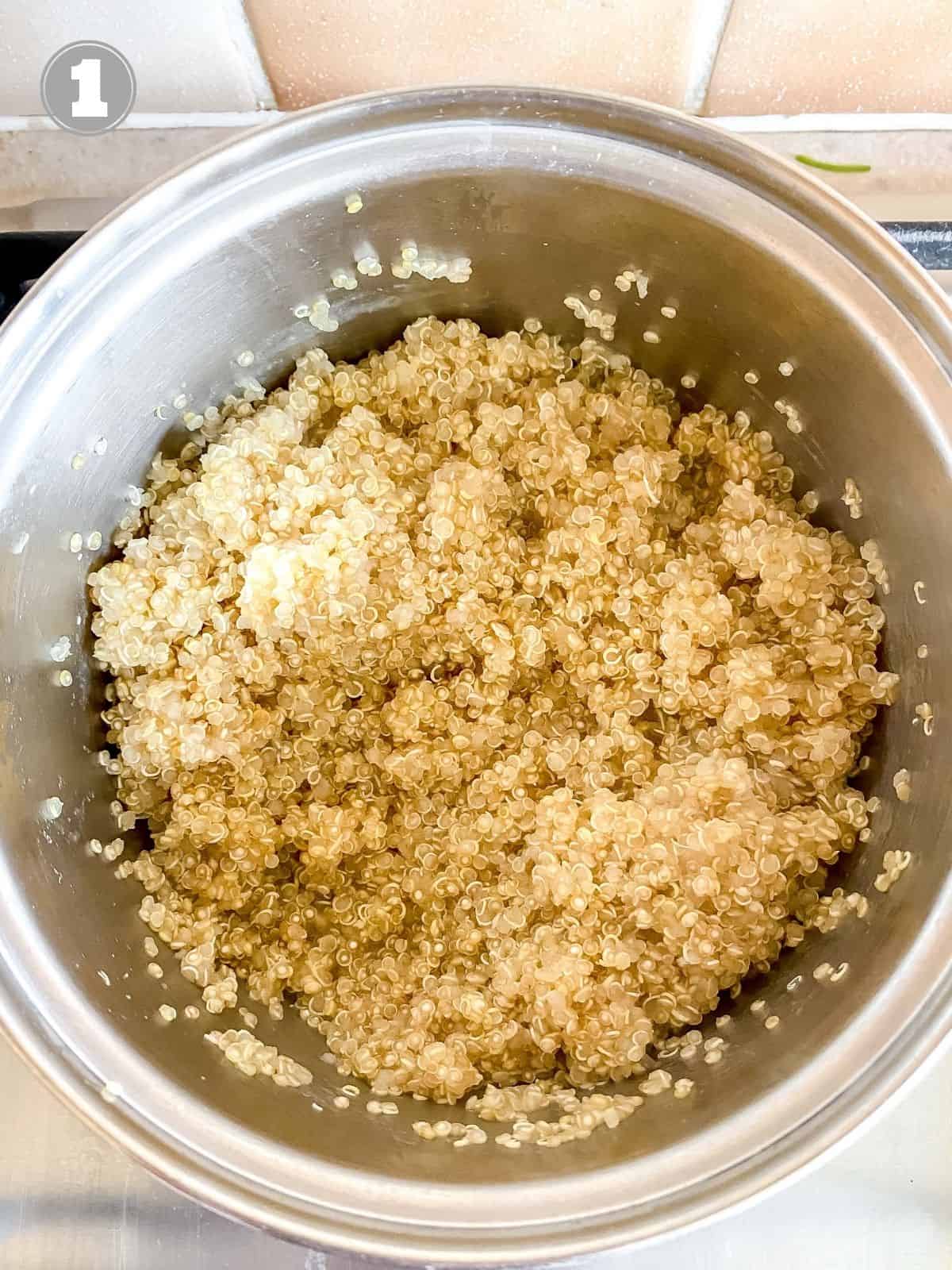 cooked quinoa in a metal saucepan.
