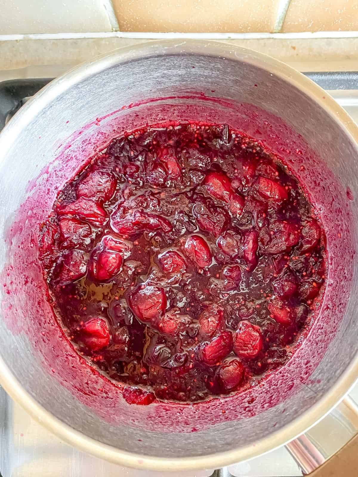 cranberries cooked down in a pot.