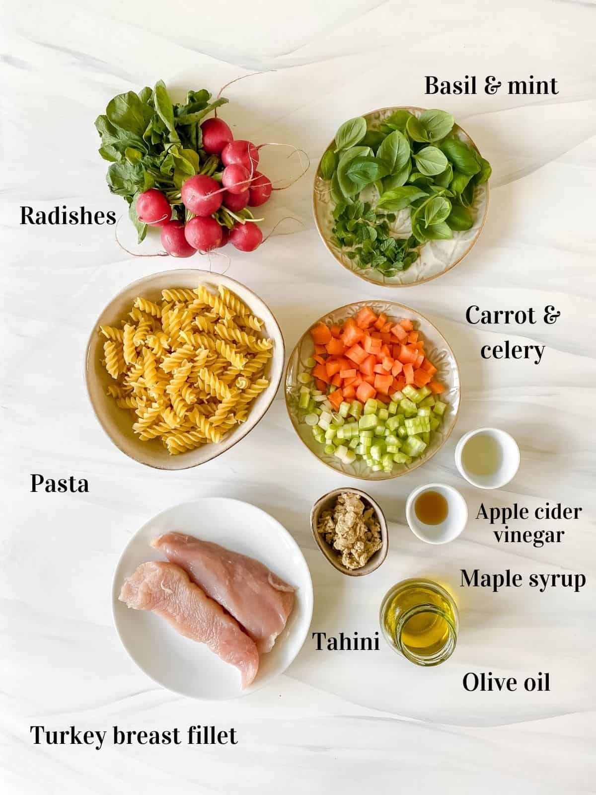 all the ingredients for turkey pasta salad in small bowls.