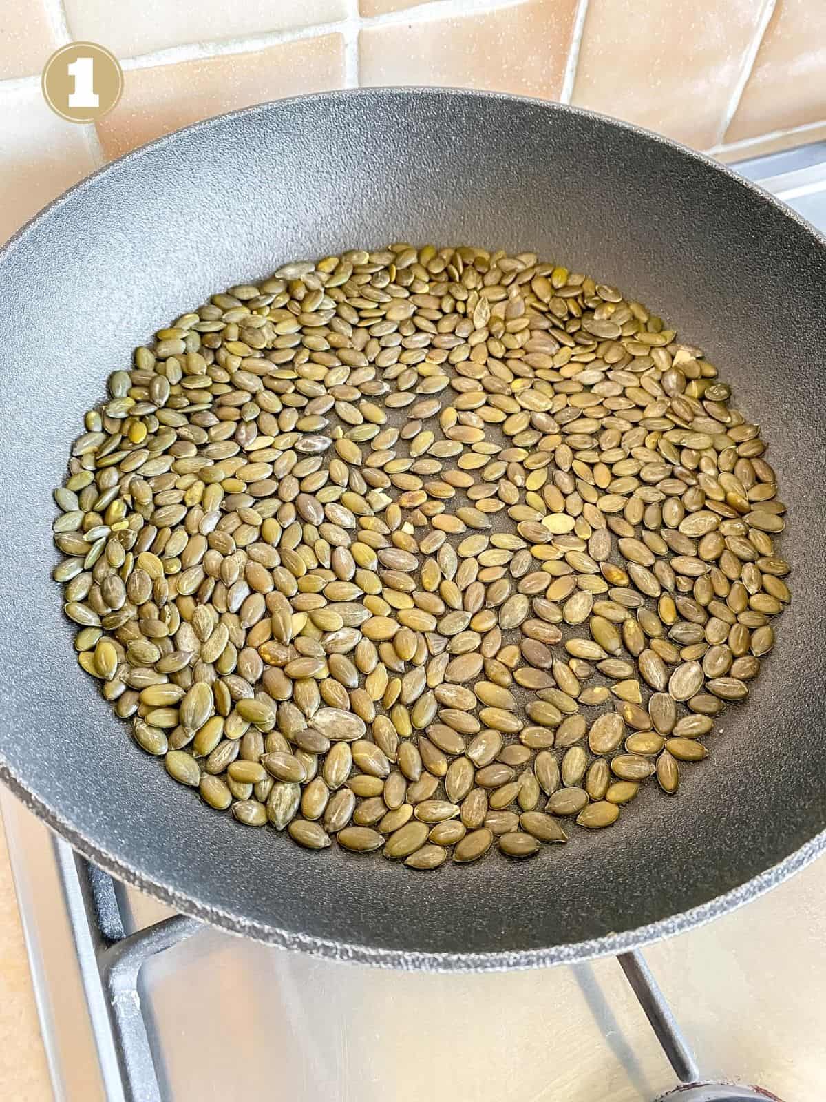 pumpkin seeds in a frying pan labelled number one.