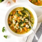 two bowls of turkey quinoa soup on a grey and white cloth.