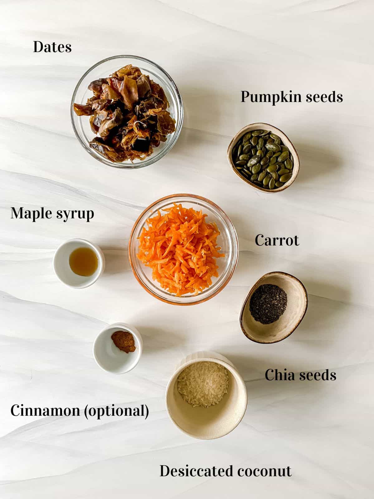all the ingredients for carrot cake bliss balls in small bowls.