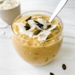 mango chia overnight oats in a glass jar with a spoon in it.